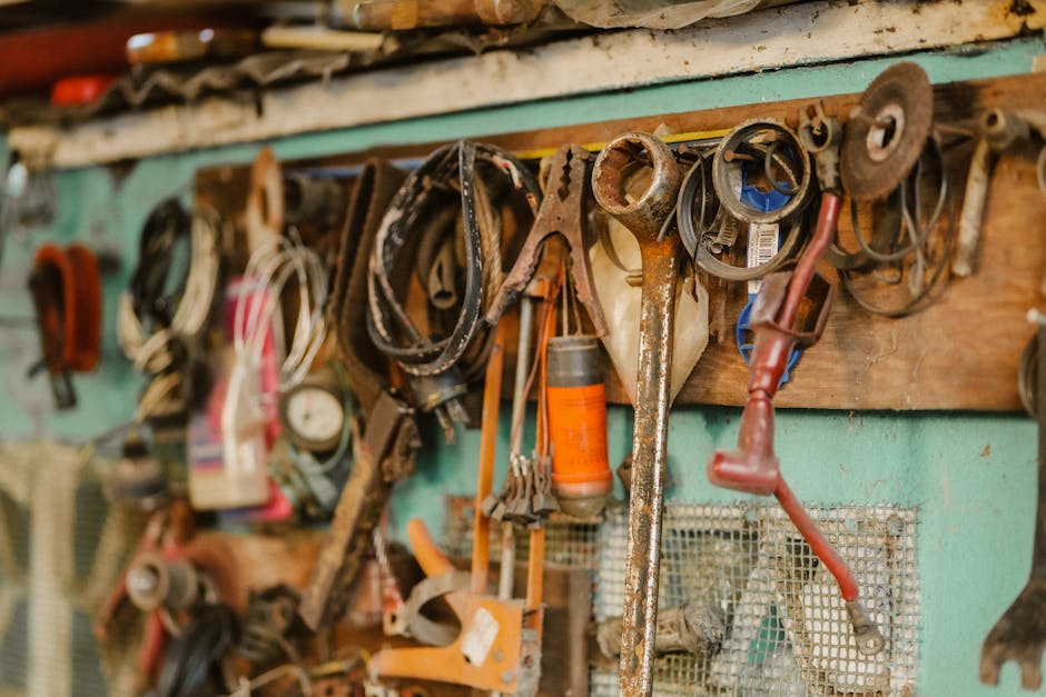 A collection of vintage tools hanging on a workshop wall, showcasing a rustic and messy appeal.