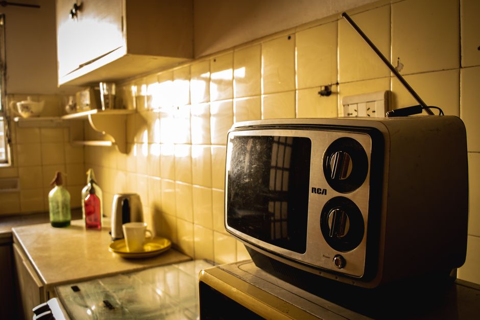 Cozy kitchen corner with vintage TV and warm sunlight, reflecting a nostalgic atmosphere.