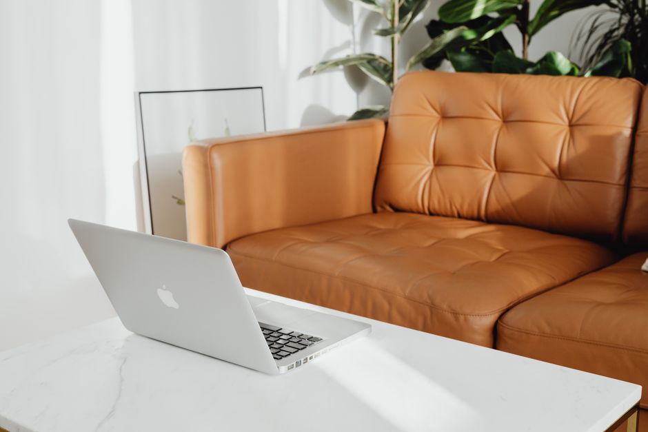 A cozy living room with a laptop on the coffee table, perfect for relaxation.