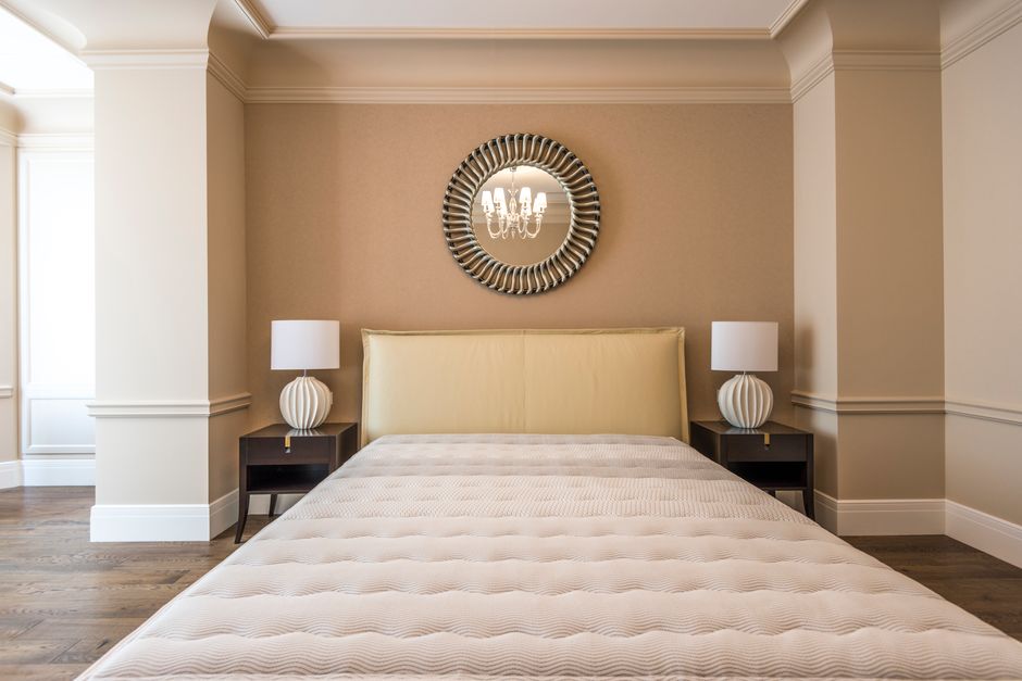 Stylish bedroom featuring a modern bed, elegant decor, and symmetrical lighting.