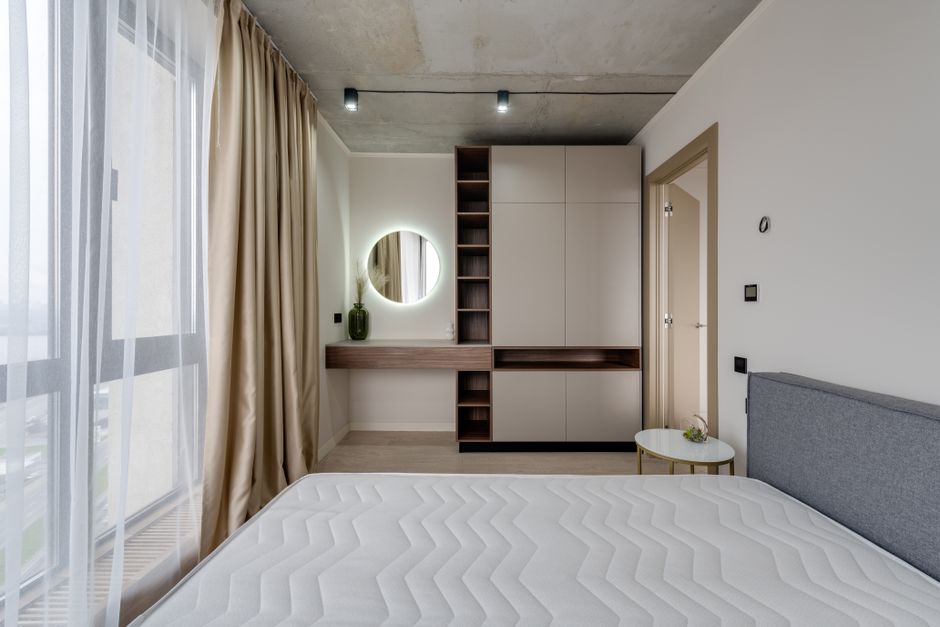 Contemporary bedroom with large window, modern furniture, and stylish decor.