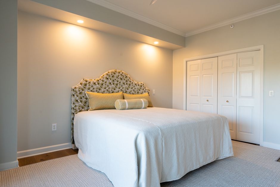 A serene and elegant modern bedroom featuring a luxurious bed with a tufted headboard.