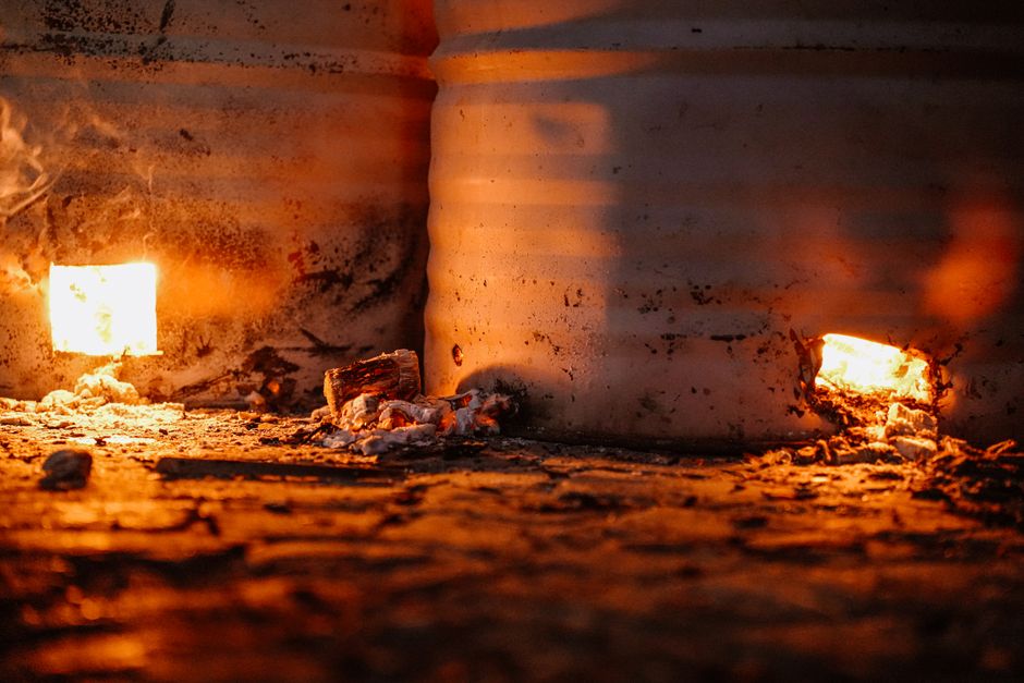 Rustic barrels with glowing embers emit warm light, showcasing raw energy and industrial ambiance.