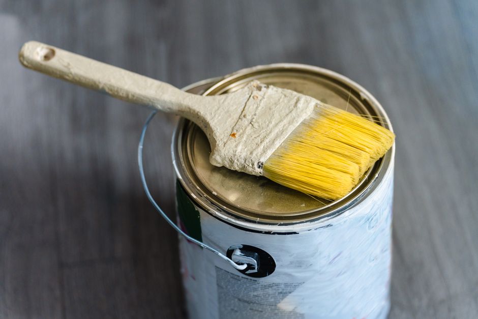A close-up image of a paintbrush resting on a paint can, ideal for DIY projects.