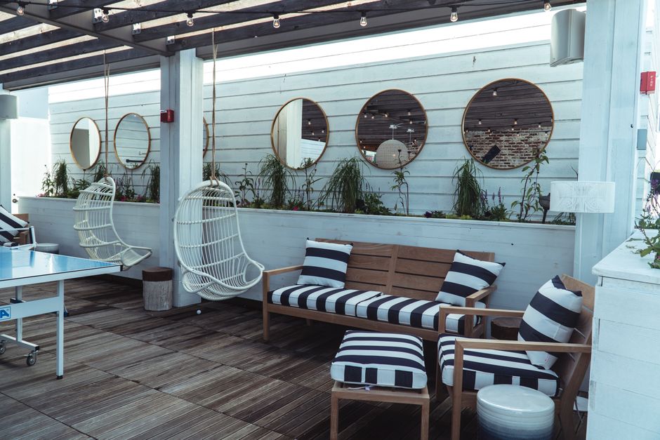 Contemporary outdoor lounge area with stylish furniture and decorative mirrors.