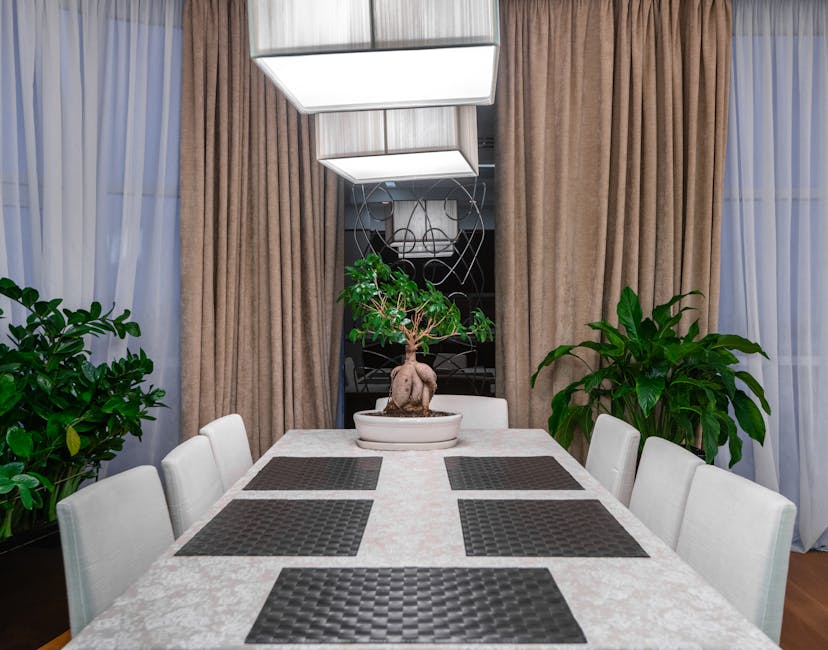 Light table and chairs placed against green potted plants in modern dining room in stylish apartment