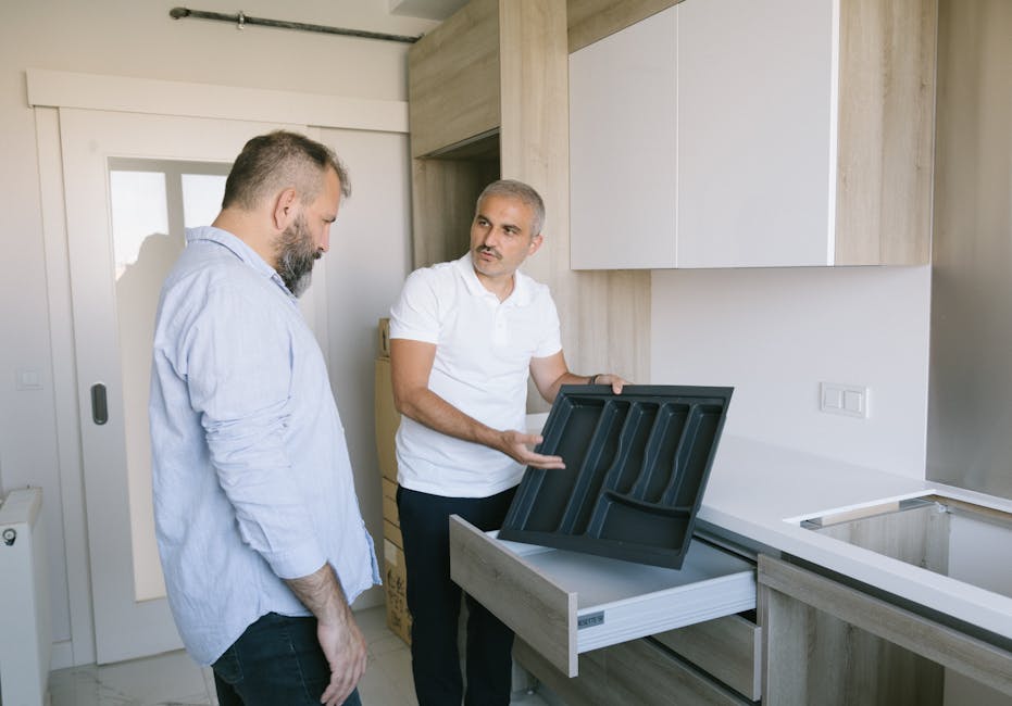 Two men in a modern kitchen discussing the installation of a drawer organizer in Istanbul, Turkey.
