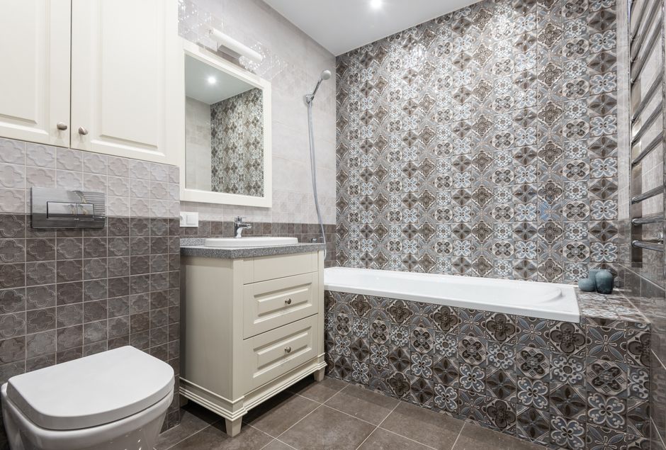 Contemporary bathroom featuring elegant decorative tiles, bathtub, and sleek cabinetry.