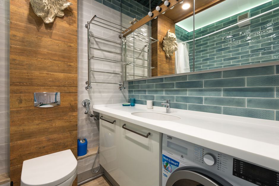 Contemporary bathroom featuring modern fixtures and decor with integrated washing machine.