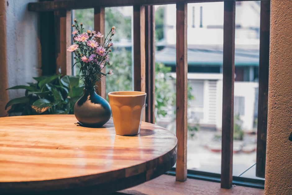 Peaceful setting with ceramic cup and flowers on a wooden table indoors.