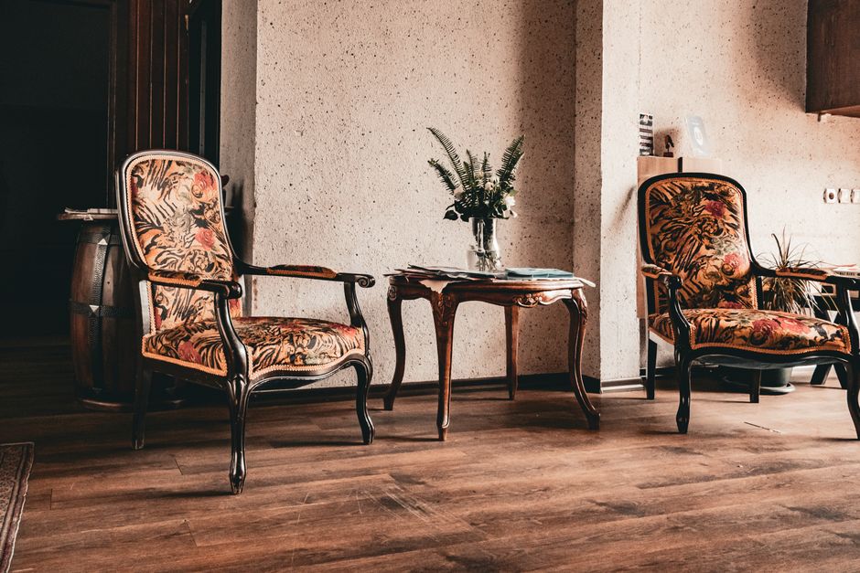 A cozy indoor space featuring vintage armchairs, ornate table, and floral decor. Ideal for classic style inspirations.