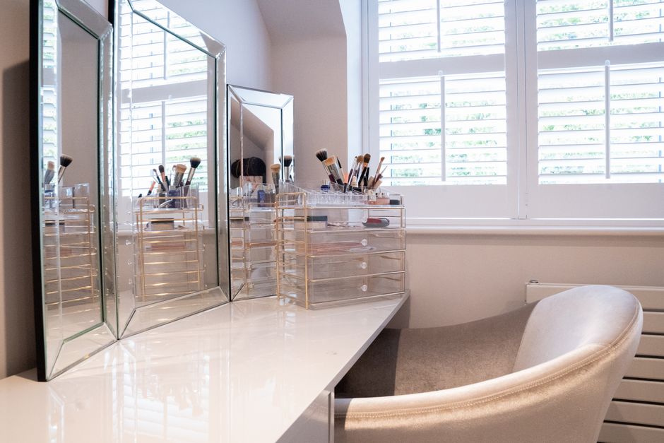Elegant makeup vanity with mirrors, brushes, and natural light from Colchester, England.