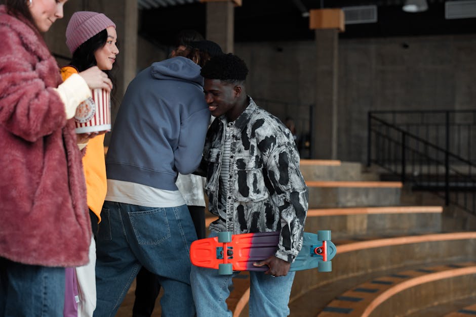 Group of young friends engaging at an indoor venue with a skateboard and popcorn.